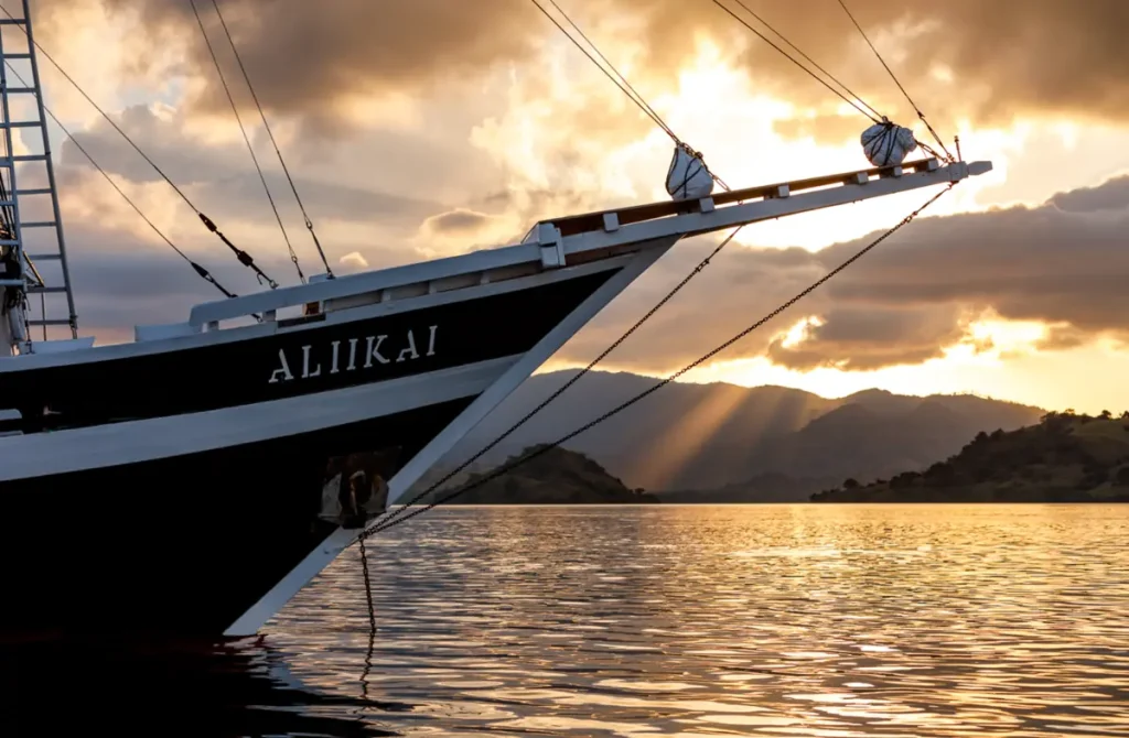 Bow of a phinisi yacht at sunset in Komodo National Park