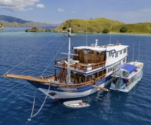Komodo Sea Dragon liveaboard yacht with dedicated dive boat anchored in clear waters.