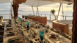 Elegant sunset dining setup on the deck of Kudanil Explorer yacht in Indonesia.