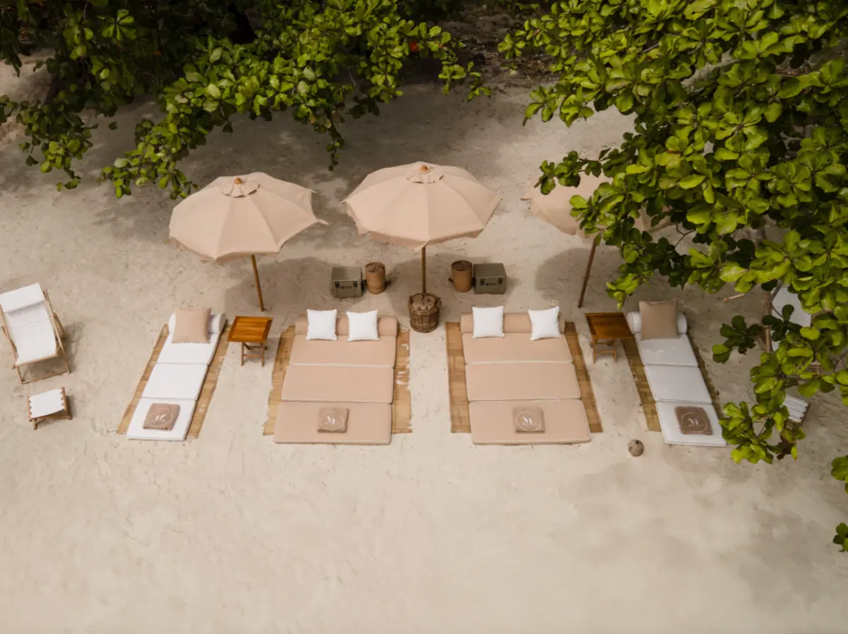 Relaxing and luxury beach setup with umbrellas and loungers in Komodo
